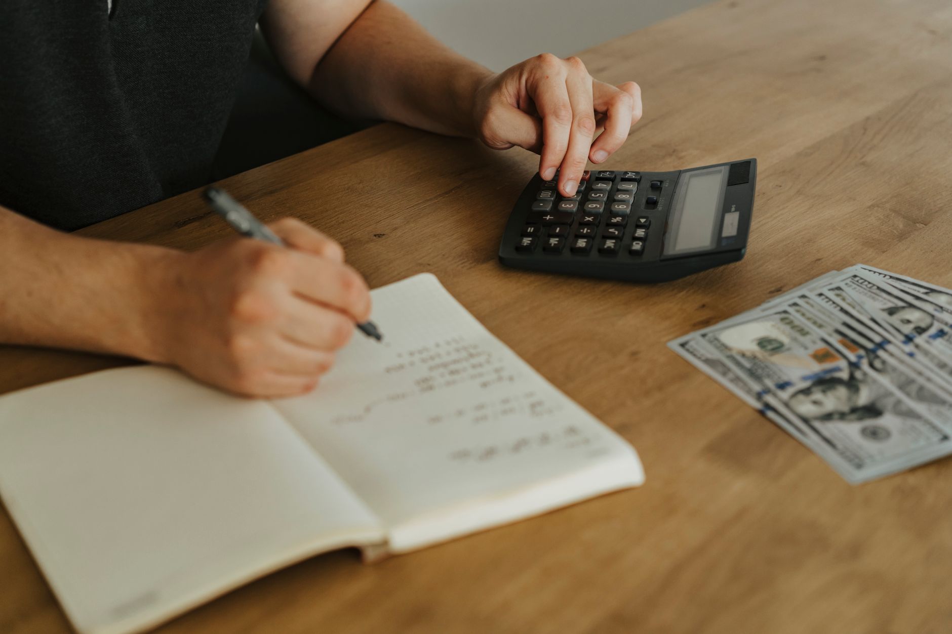 a person writing on white notebook